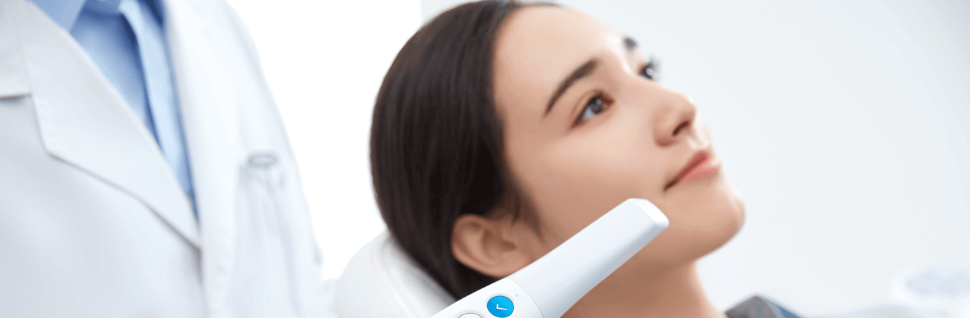 Frau bei der Intraoralscannerbehandlung